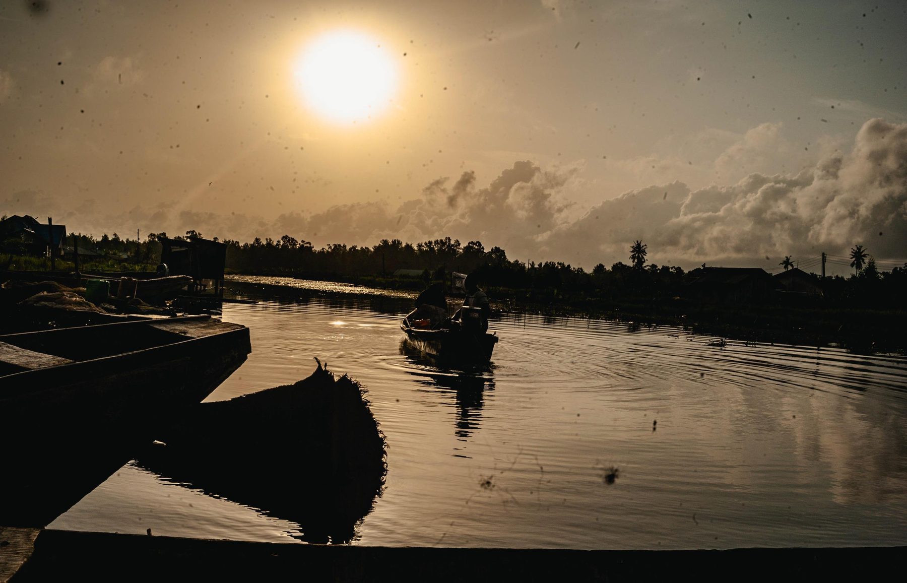 Sunset over the Niger Delta creeks with fishing boats on the water